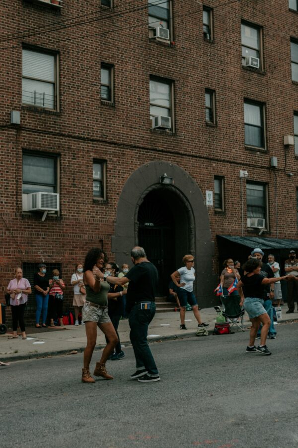 Grupo de personas afuera de un edificio de ladrillo, escena urbana verano Nueva York
